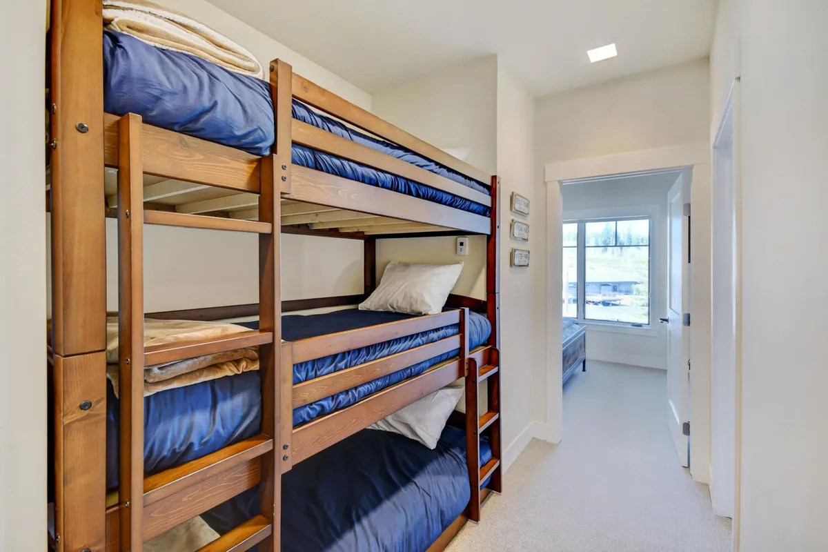 A cozy sleeping area with well-made bunk beds, soft pillows, and a staircase to the upper bunk. The space feels playful yet comfortable, perfect for children or groups, and suggests flexibility in sleeping arrangements.