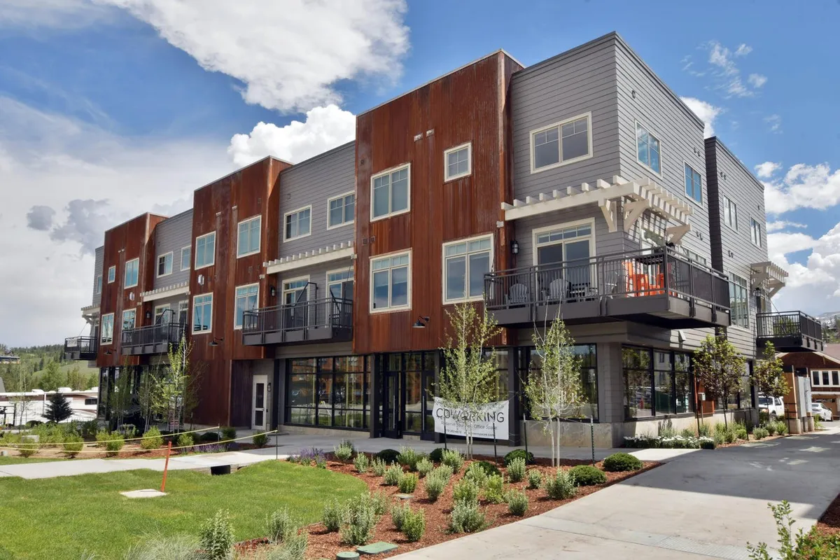 This exterior image displays the property’s modern architecture with several balconies overlooking lush landscaping. The atmosphere is welcoming, and the balconies are clearly highlighted as prime spots for enjoying sunsets and social gatherings.